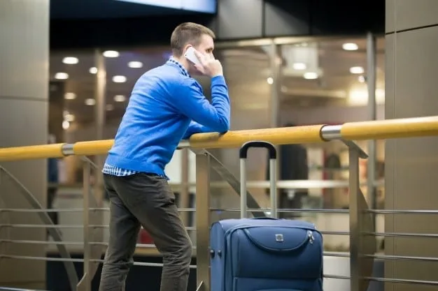 Man waiting at an airport with excess baggage